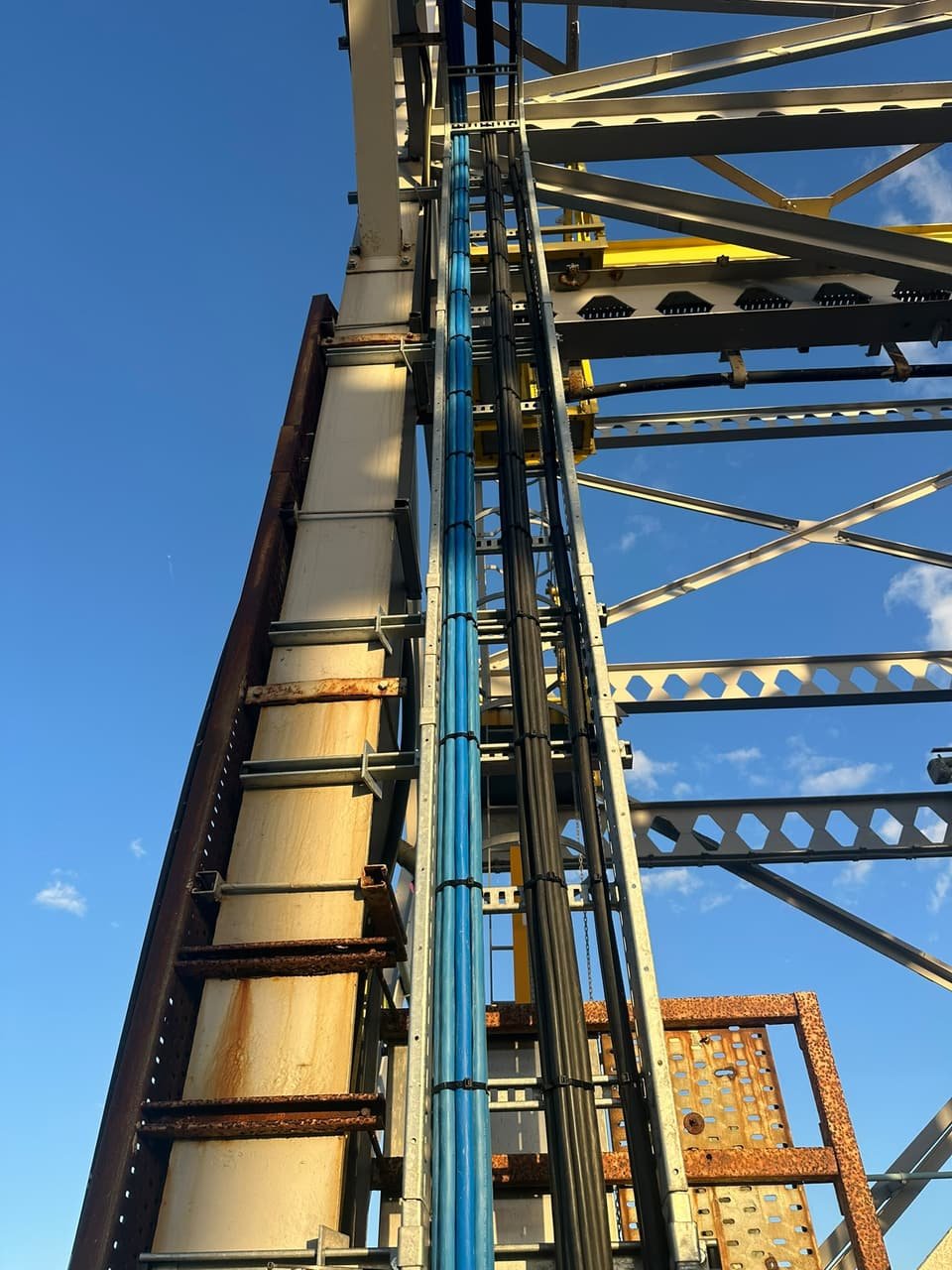 The vertical cable riser up the jetty steelwork, with the new blue and black cables tied in