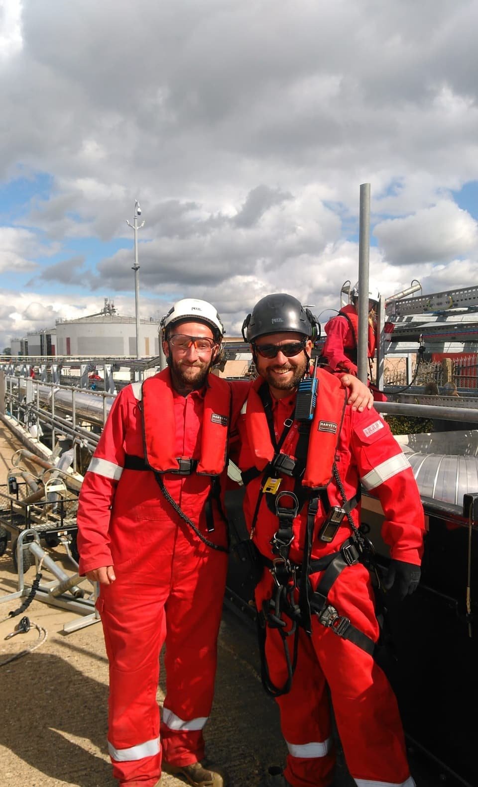 Two RAT Work technicians in flame-resistant coveralls, helmets and harnesses on the terminal jetty