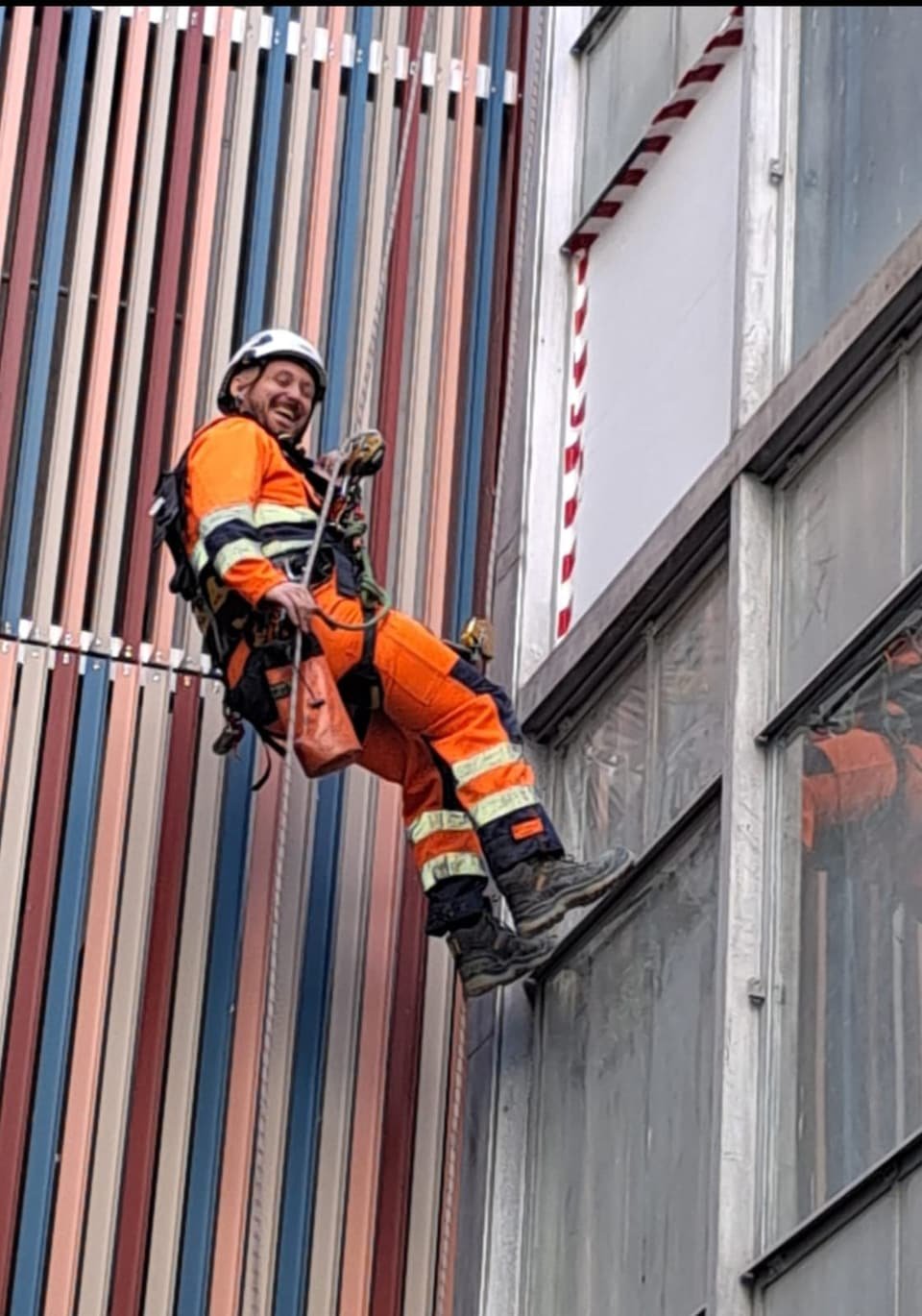 RAT Work technician in hi-vis descending a building façade on rope