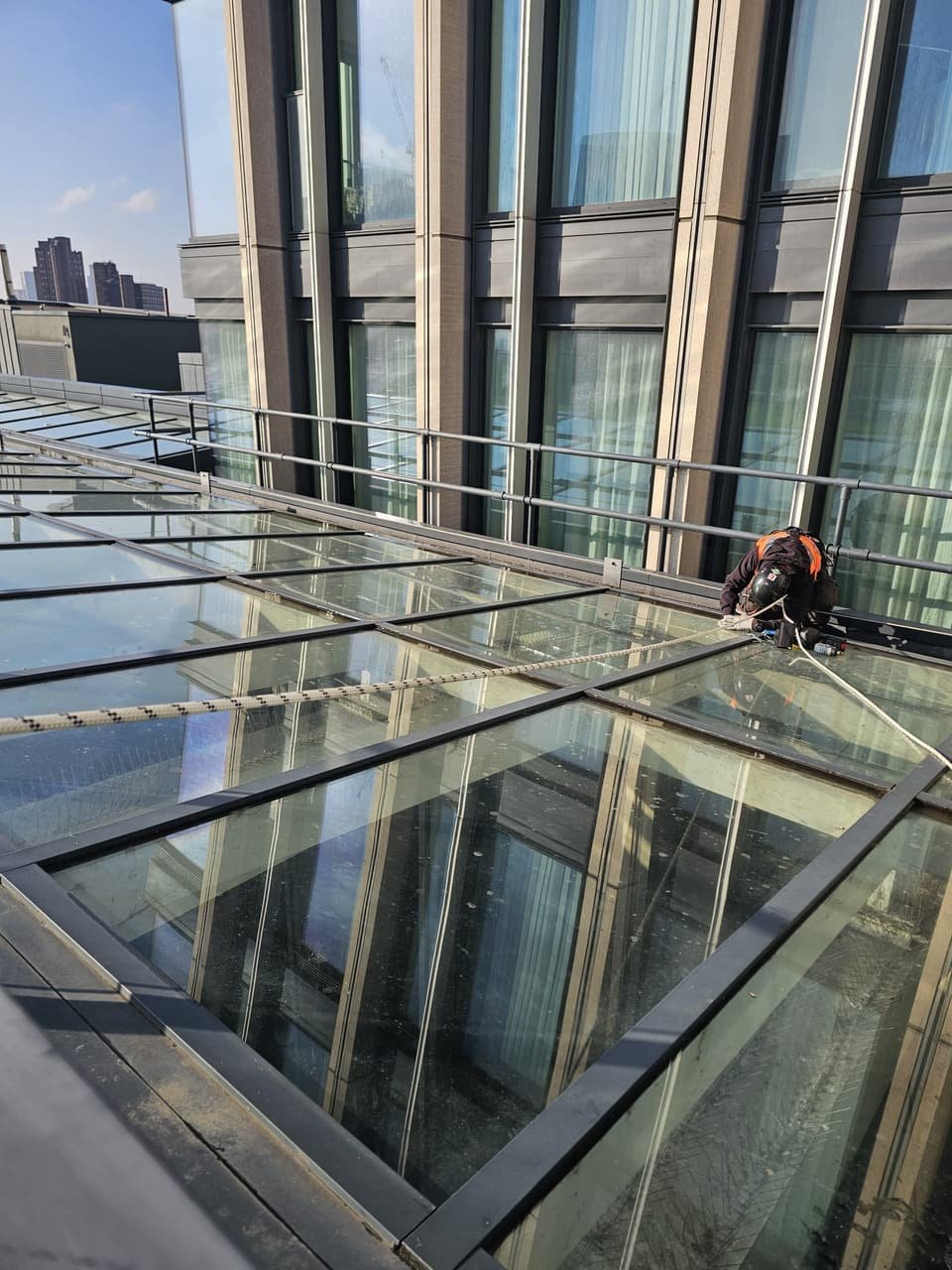 RAT Work technician rigged on a glazed atrium roof below a hotel façade