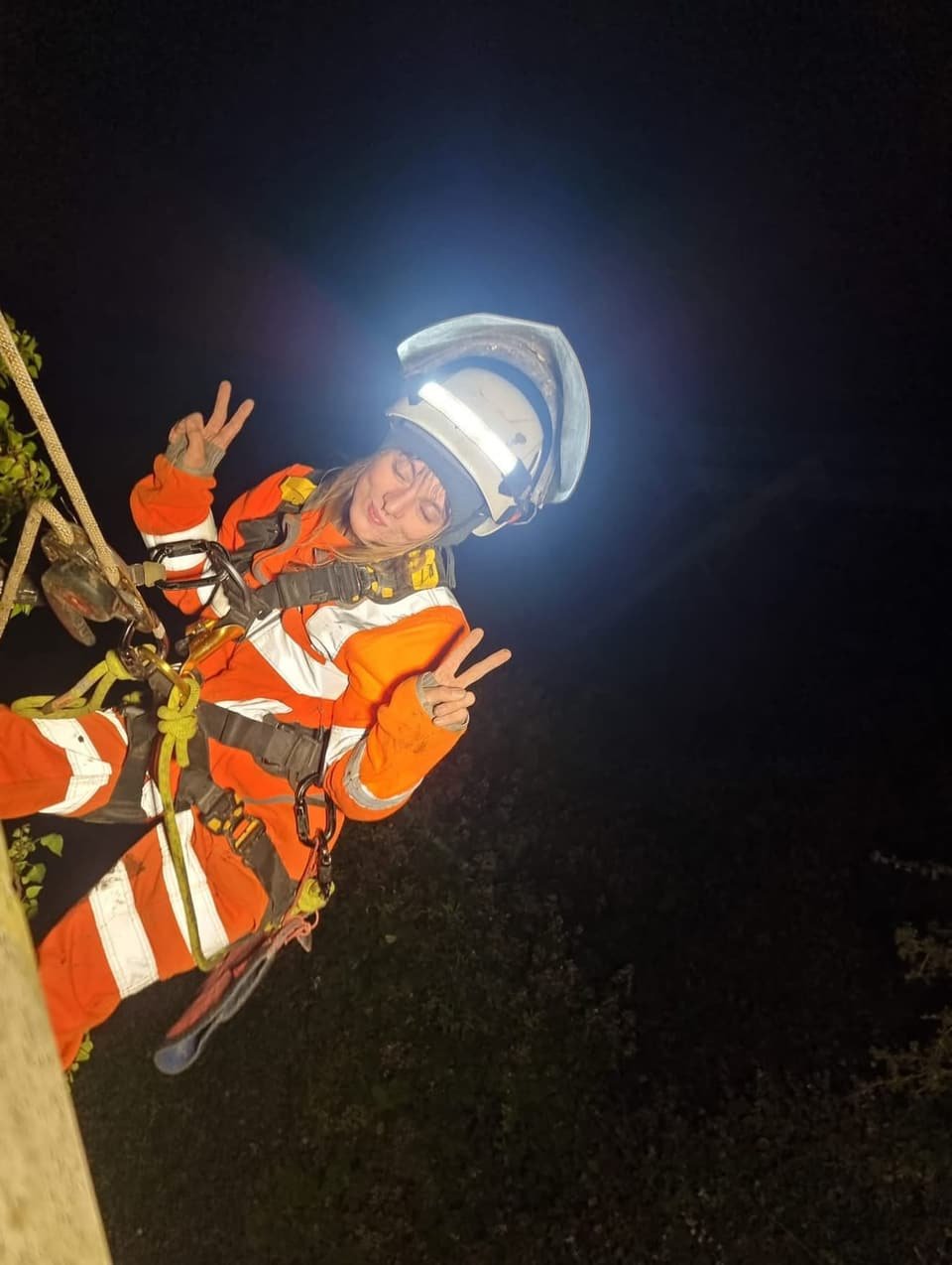 Technician on rope at night under a headtorch