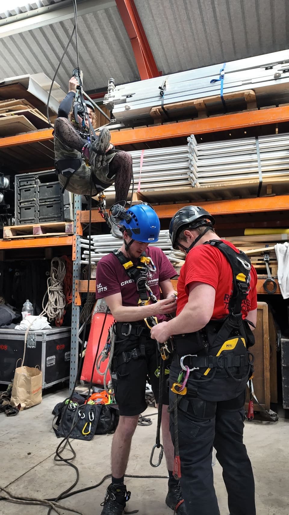 Technicians checking each other’s rigging at a technique day, with a third ascending the rope above